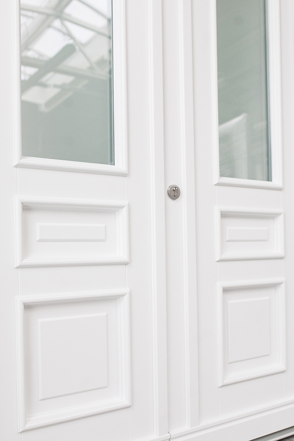 Weiße Hauseingangstür mit Schutzrosette und Ornamentglas