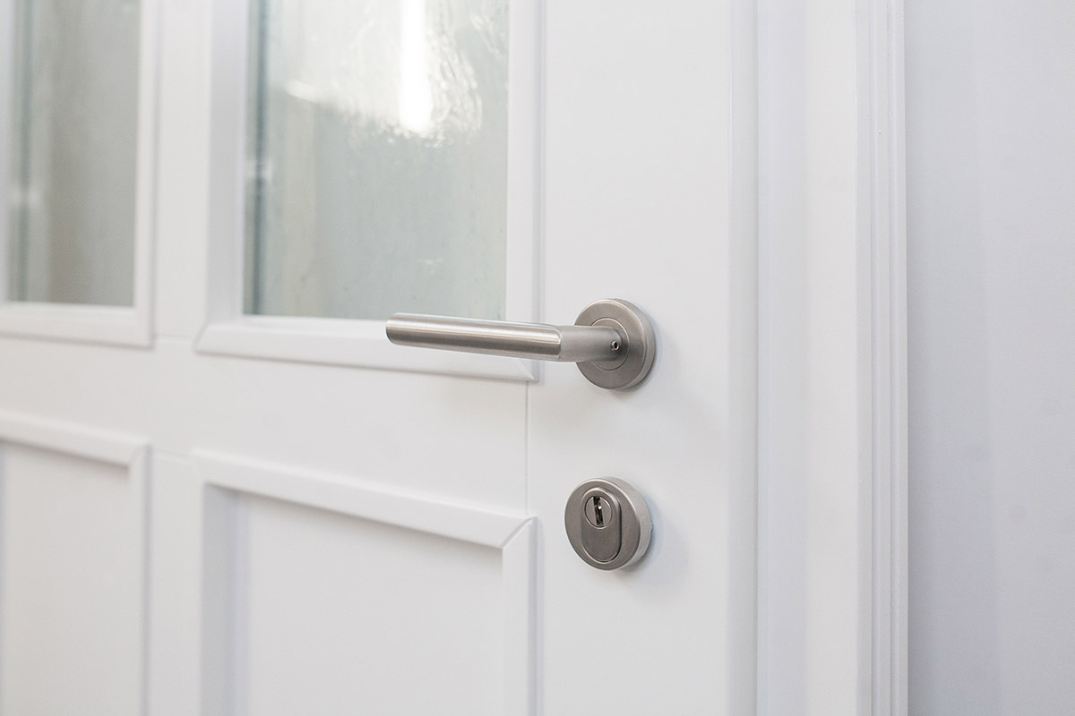 Rosette und Drücker aus Aluminium an Holzhaustür